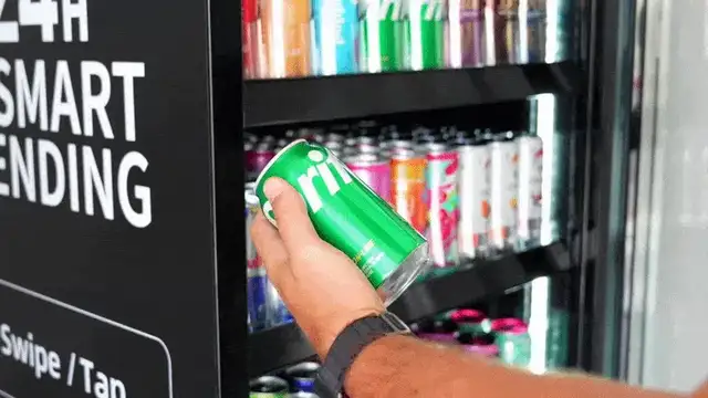 Hand taking a can from a smart cooler shelf